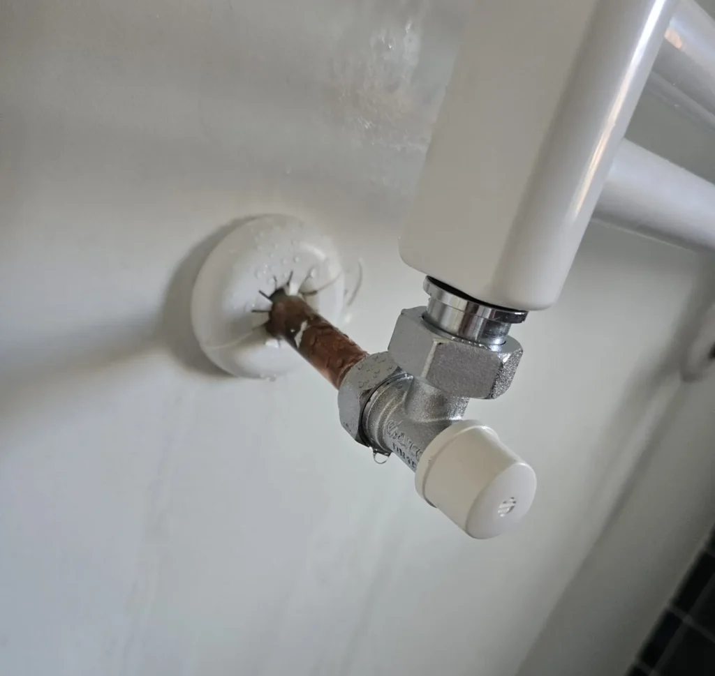 Fontanero reparando una fuga de agua bajo el fregadero en Fuenlabrada